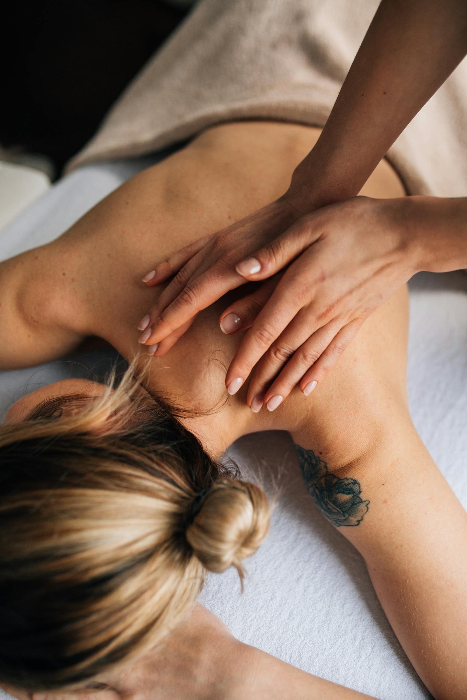 Female receiving a soothing massage in a tranquil spa environment, focusing on wellbeing.